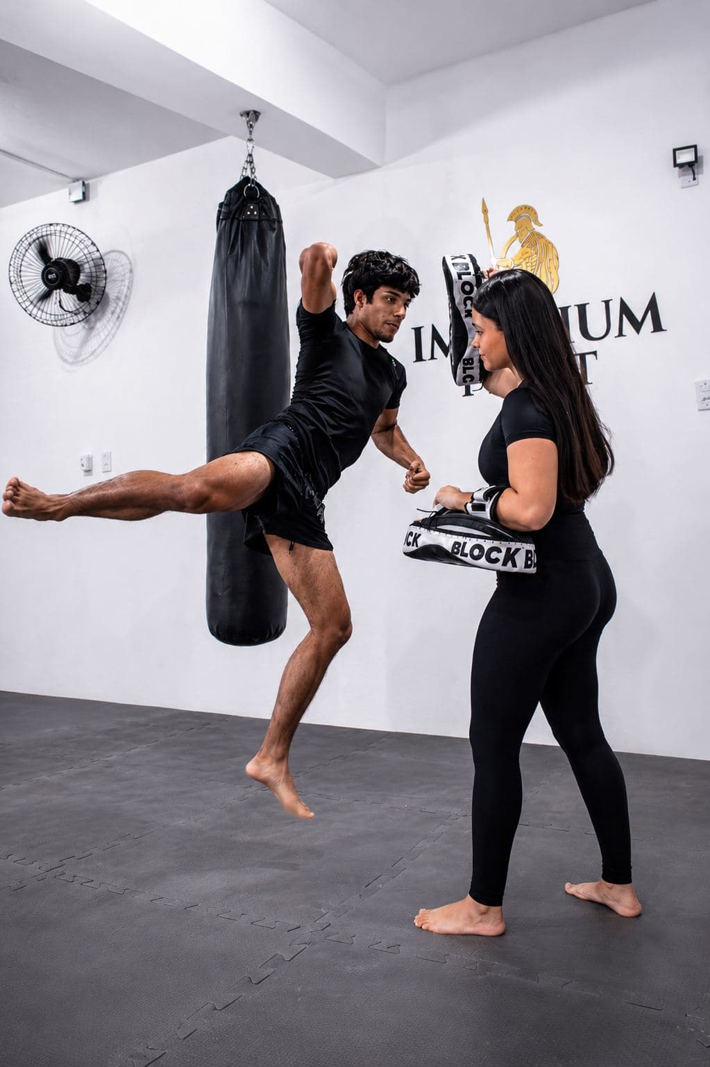 Aluno aplicando um chute alto em salto durante treino de Muay Thai na Imperium Fight