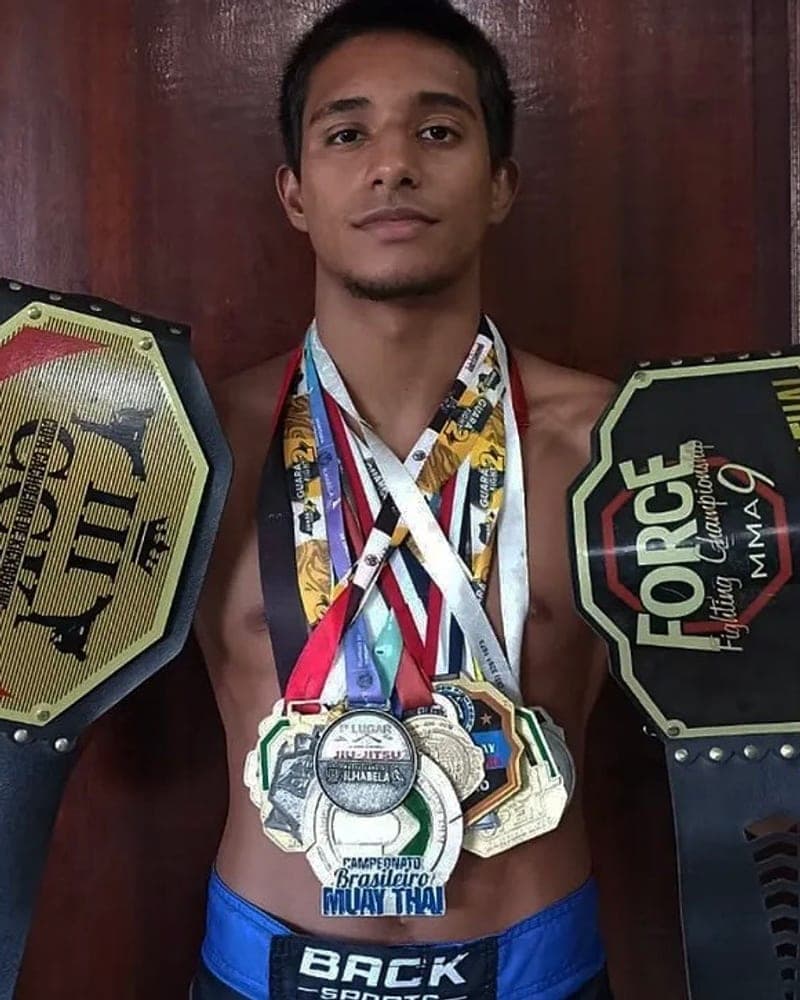 Matheus, cofundador da Imperium Fight, com os cinturões e medalhas conquistados em campeonatos de Muay Thai